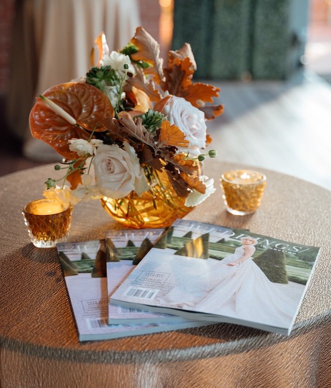 Weddings in Houston magazines resting on gold linens and autumn florals. 