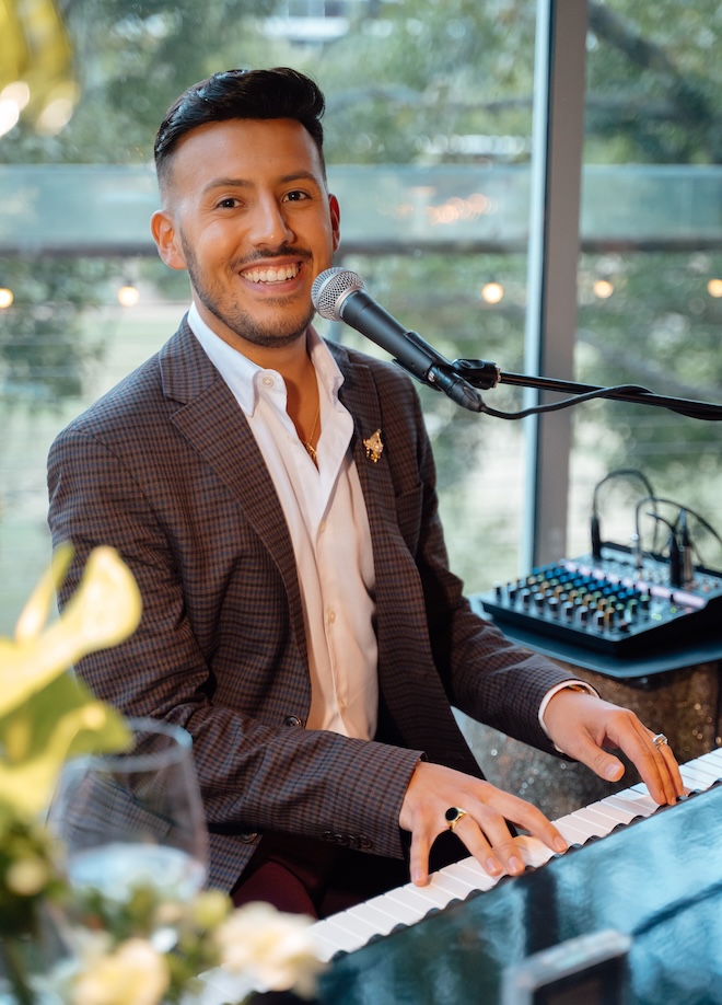 Ben Chavez playing the piano and smiling. 