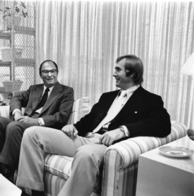 A historic photo of two men sitting on the couch. 