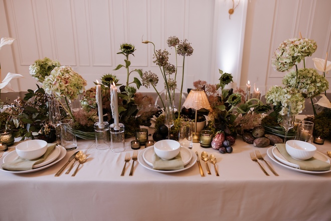 Earthy-toned florals and taper candles decorate the reception table. 