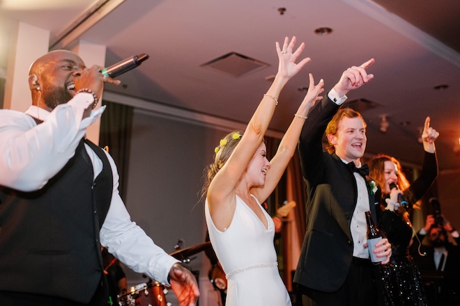 The bride and groom dance and sing on stage at their wedding reception at The Tremont House.