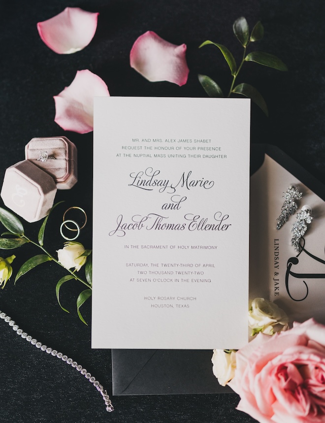 An invitation suite with a black background and black lettering on white stationery. 