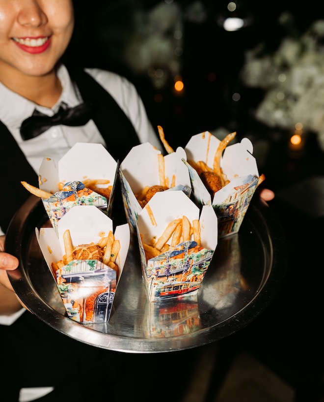 New Orleans inspired take-out boxes with fires are served to wedding guests for a late-night snack. 