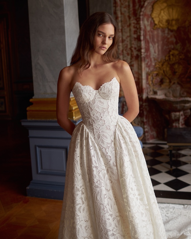 An all-lace gown with a corset top and a basque waist. 