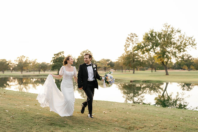 The bride and groom hold hands as they run on the golf course of the Pine Forest Country Club.