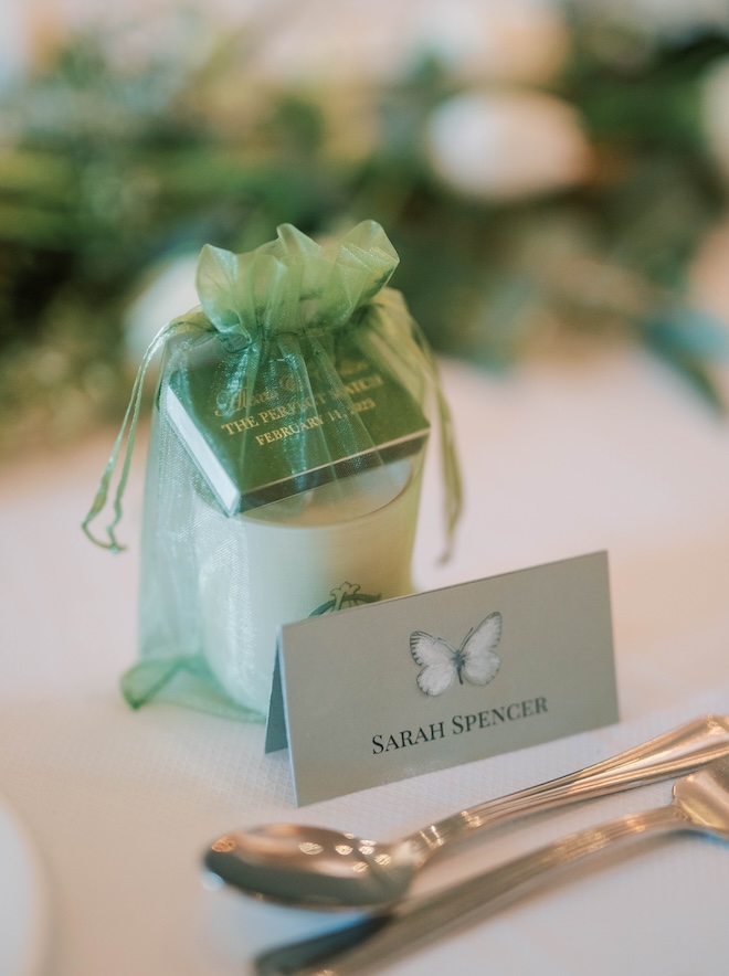 Green matchboxes and candles are at each place setting for guests at the wedding reception.