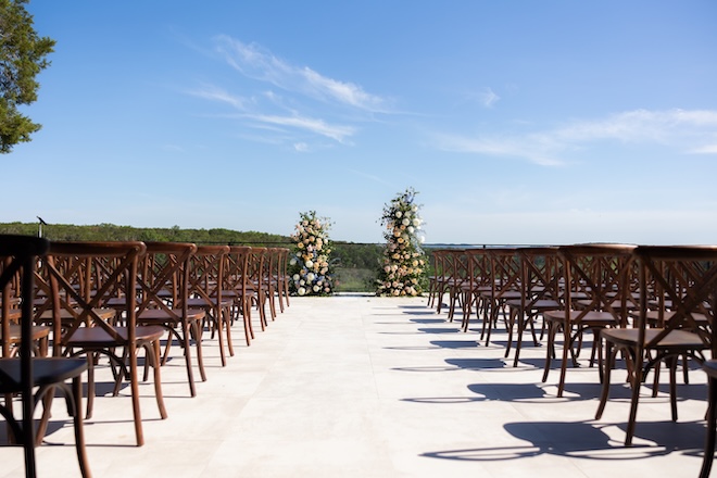 A pastel floral arch decorates the wedding ceremony. 