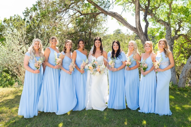 The bride and her bridesmaids hold their wedding bouquets in the Texas Hill Country.