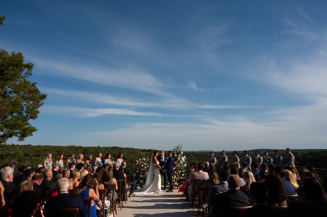The couple holds hands at the altar of their wedding ceremony in Wimberley, Texas.