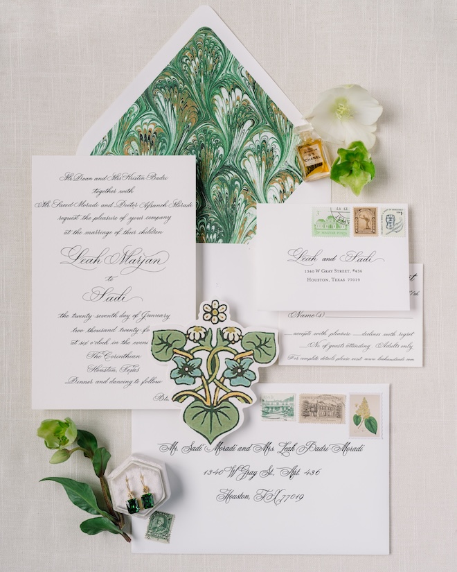 The bride and grooms wedding stationery is features shades of green and an patterned envelope liner. 