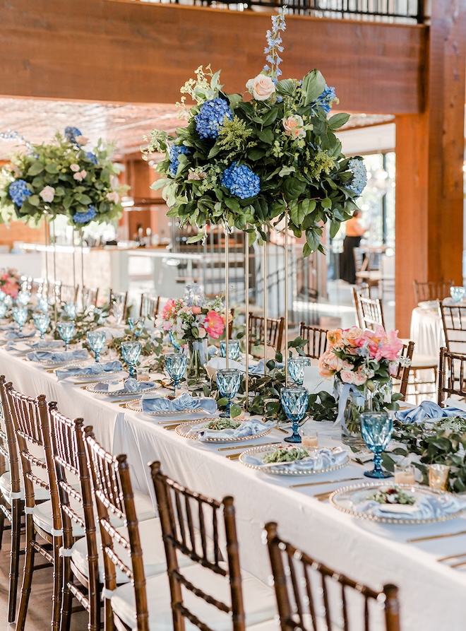 Blue dinnerware and light blue napkins decorate the reception tables. 