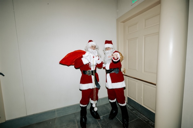 Two guys dressed up as Santa.