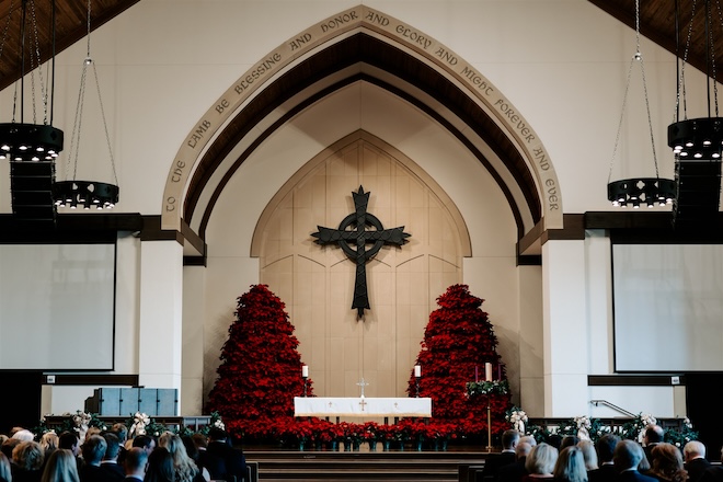 The altar at the church decorated with poinsettia trees for a Houston holiday wedding. 