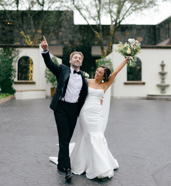 The bride and groom cheering at The Bell Tower on 34th. 