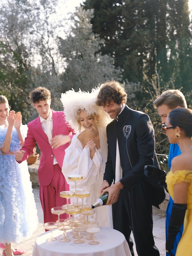 The bride and groom pour champagne for their out-of-town wedding guests in Spain.