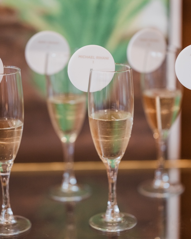Champagne glasses with a topper that has the guests name and table number. 