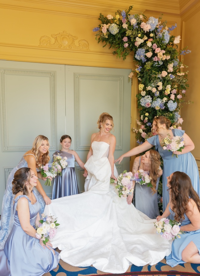 The bride and her bridesmaids stand under a floral installation that decorates the front of Hotel ICON's ballroom. 