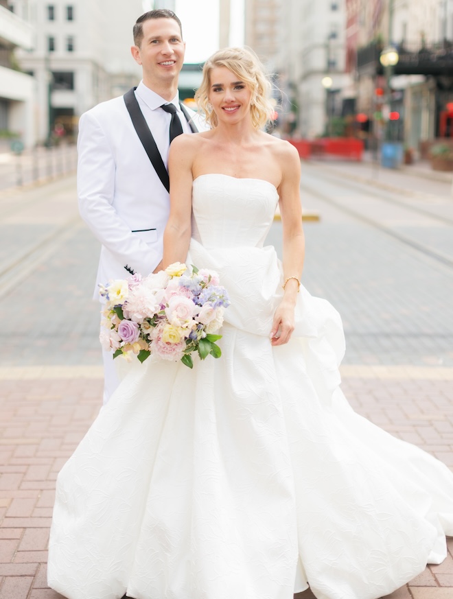 The bride and groom stand on Main Street in downtown Houston following their ceremony at Hotel ICON. 