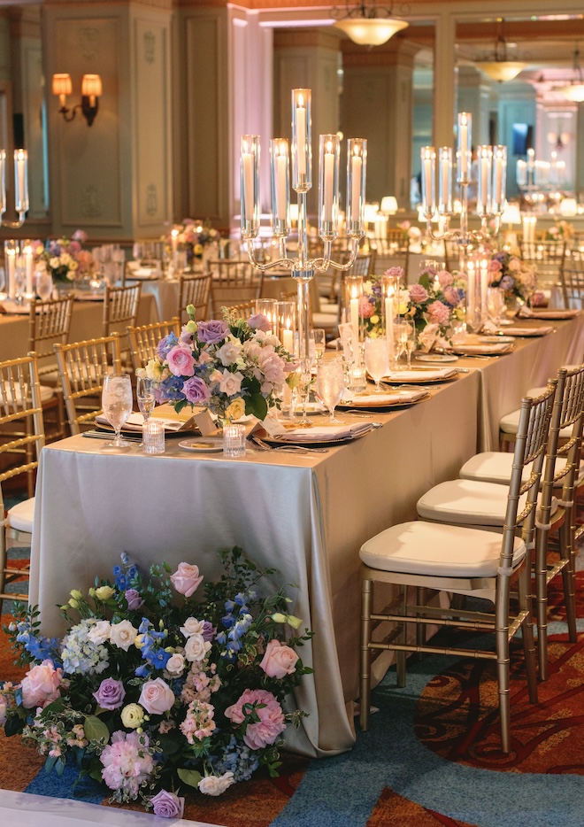 Pastel floral arrangements decorate the reception tables of the European countryside wedding. 