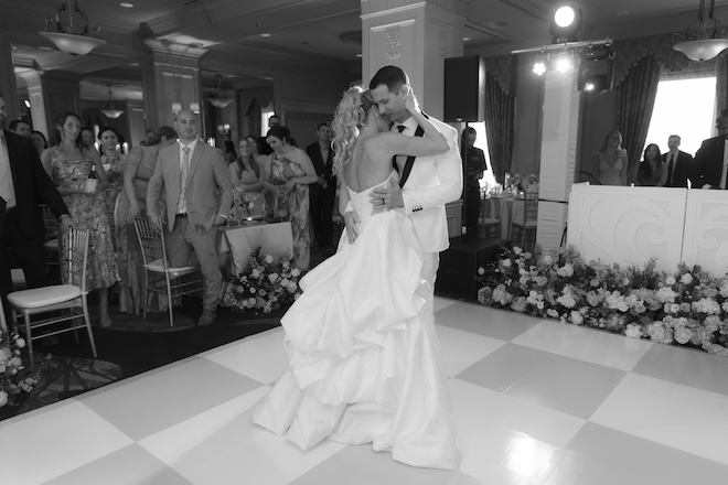The bride and groom share their first dance at their European countryside wedding as guests watch. 