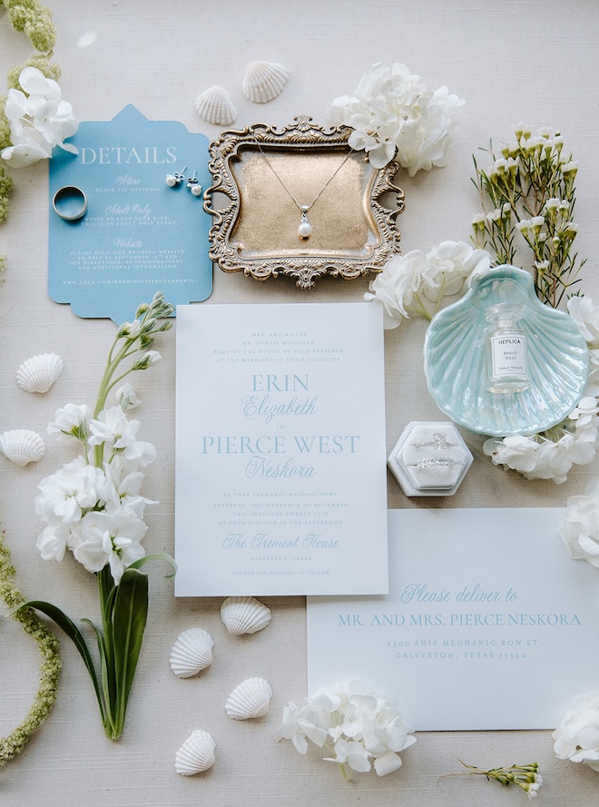 A flat lay of the couples wedding invitations and wedding day accessories.