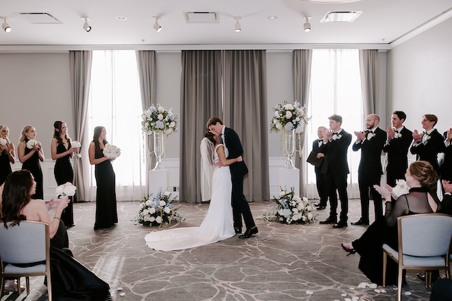 The bride and groom share a kiss at the altar of their ballroom wedding at The Tremont House. 