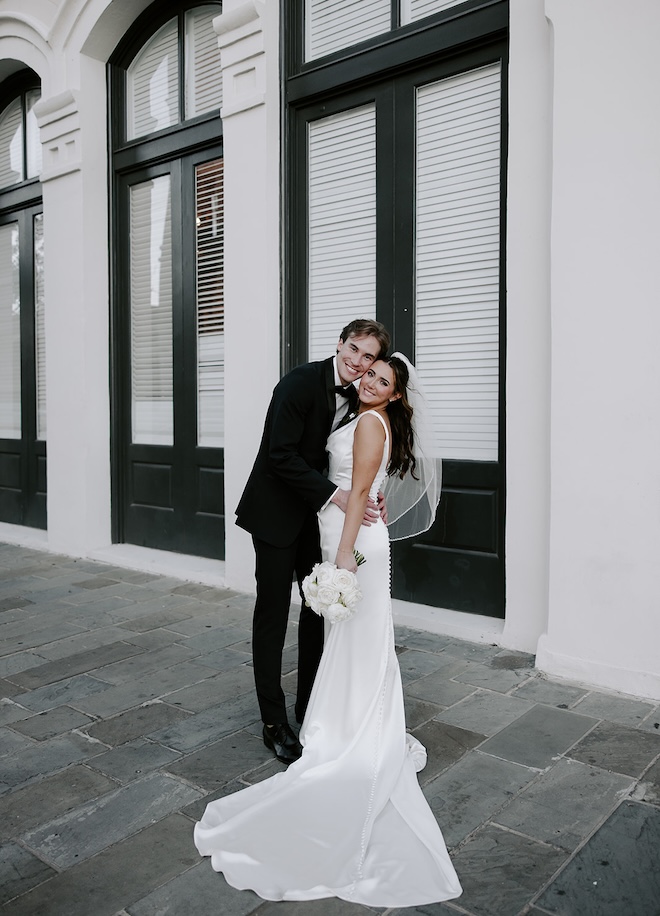 The bride and groom smile in front of their wedding venue, The Tremont House.