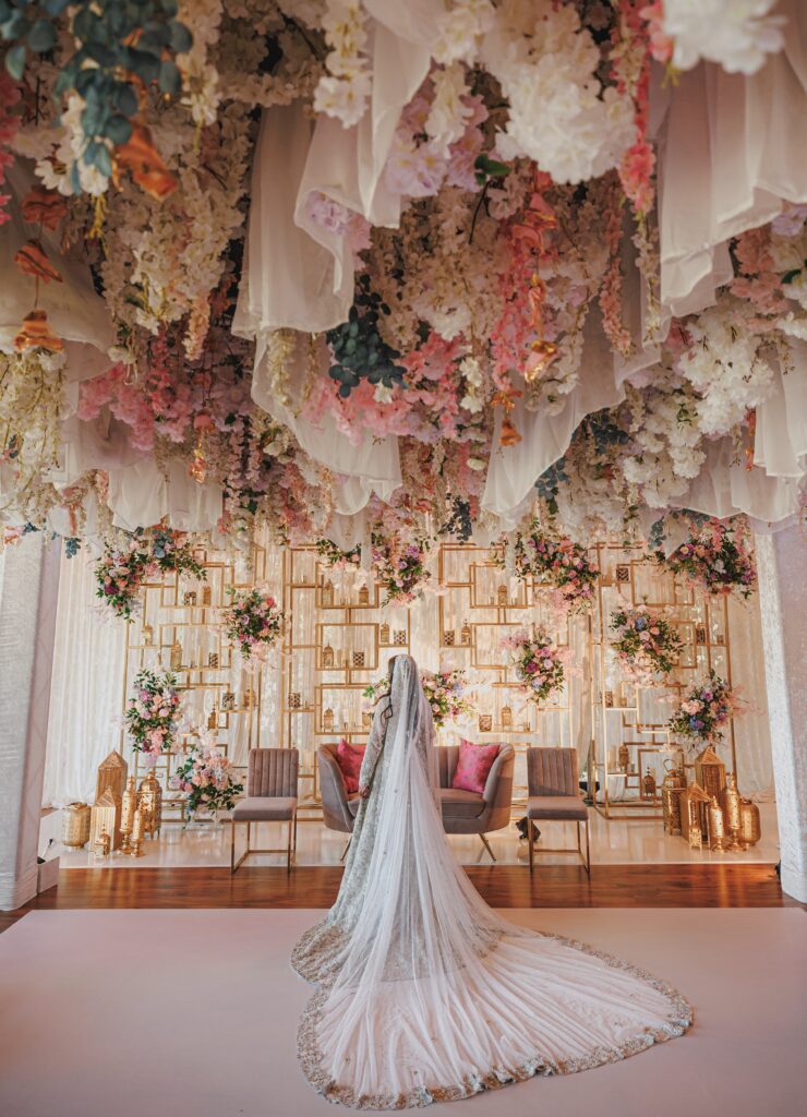 The bride under a canopy of draping and florals. 