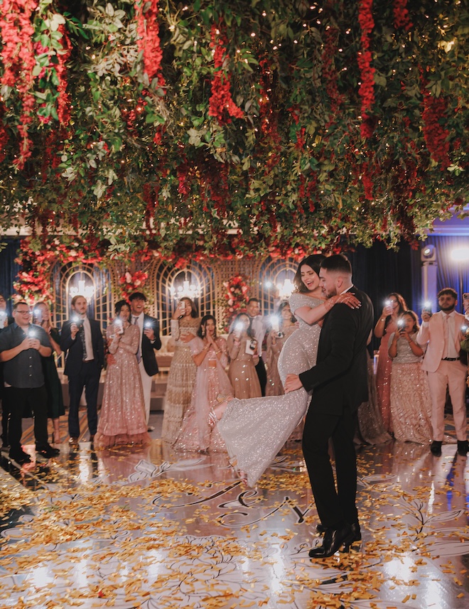 The groom picking the bride up on the dance floor. 