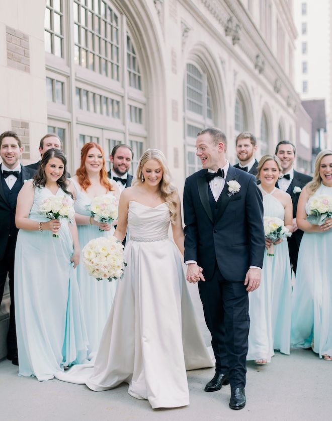 The bridesmaids wear light blue gowns for the bride and groom's wedding day.