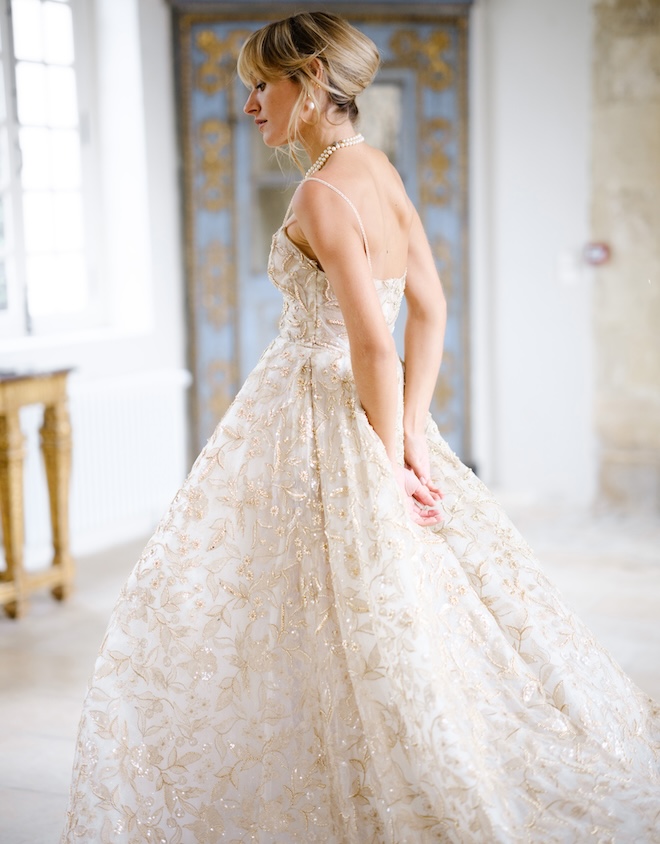 A bride wearing a gold sparkly wedding gown. 