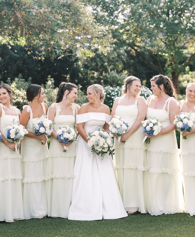 The bridesmaids wear butter yellow dresses for the couple's outdoor wedding in Houston.