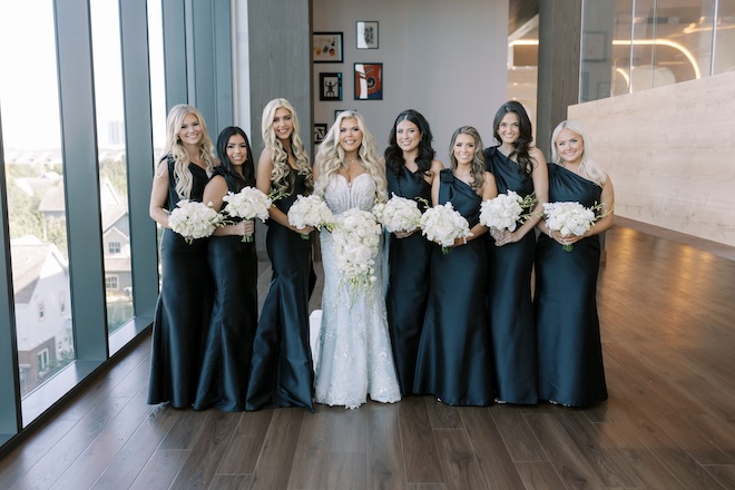 The bridesmaids wear black dresses for the bride's wedding at Thompson Houston, by Hyatt. 