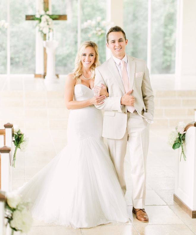 A bride and groom posing for a photo in front of the altar. 