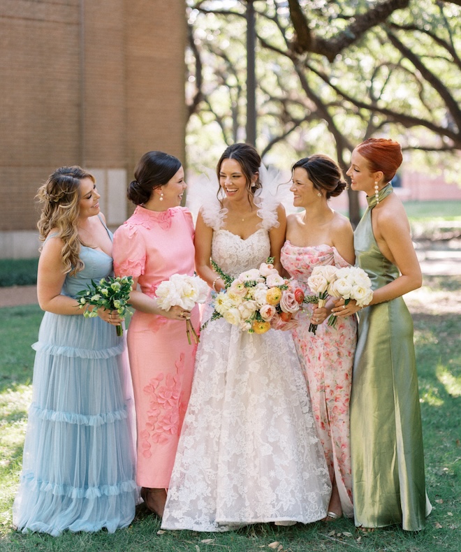 The bride and her bridesmaids laugh outside a church in Houston.