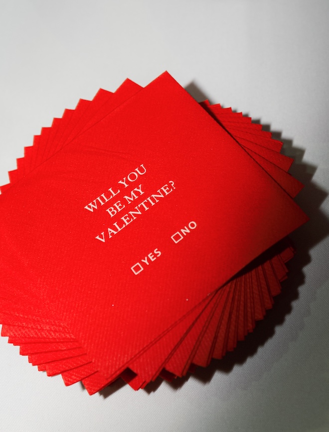 Red cocktail napkins are placed on the bars at the couples wedding reception.