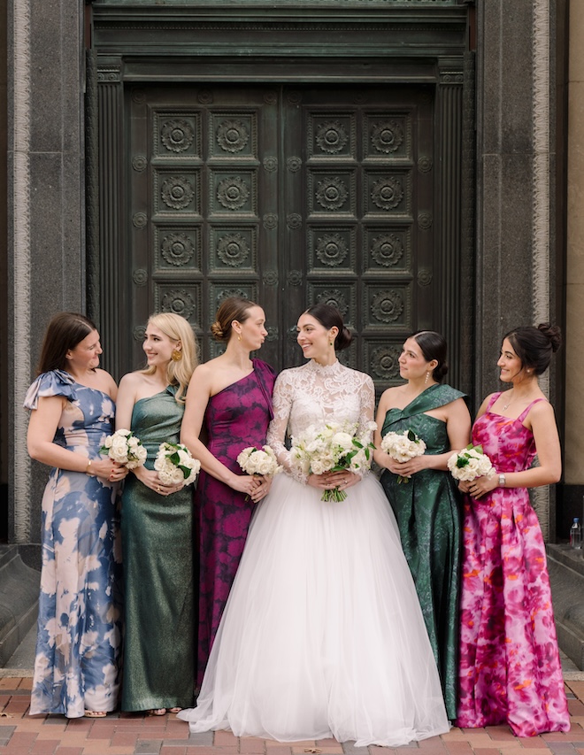 The bridesmaids wear dresses that are mix matched next the bride. 