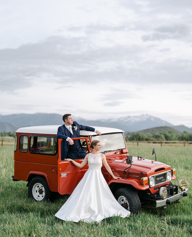 The bride and groom ride off in a vintage red Toyota for their Utah wedding day. 