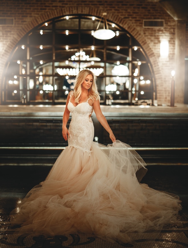 A 2016 bride wearing a sleeveless wedding gown with a mermaid shape. 