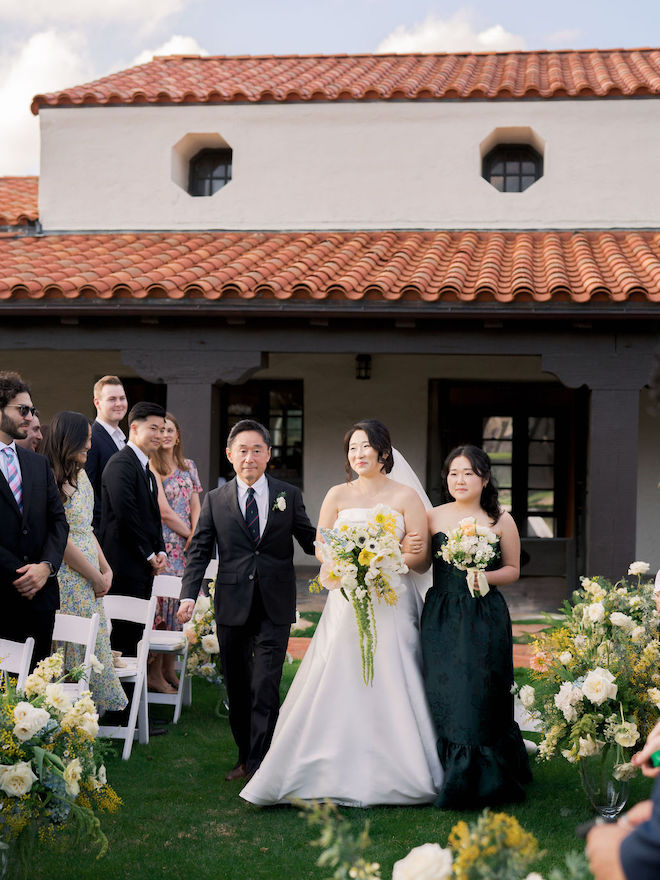 Bride walking down the aisle with Father and Sister.