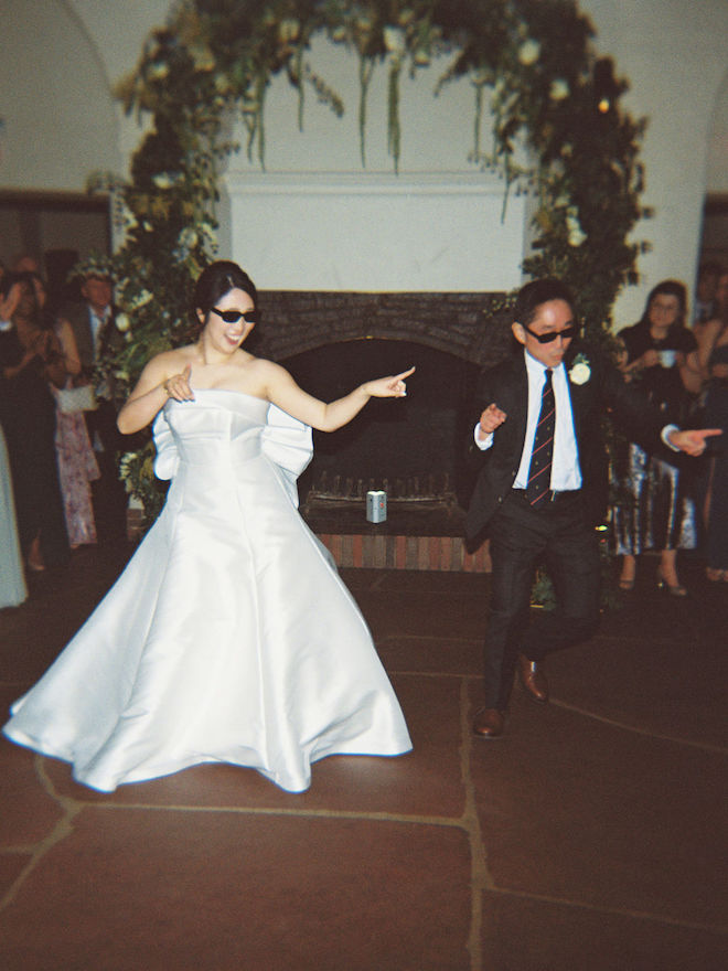 Bride and father of the bride dancing on dance floor with sunglasses on.