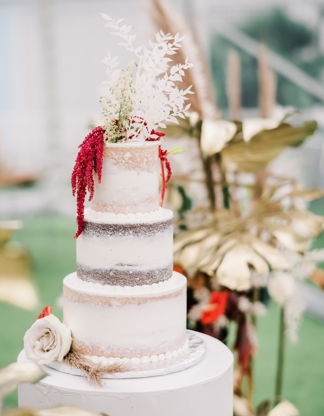 Red florals top the white wedding cake for red wedding inspiration in Galveston. 