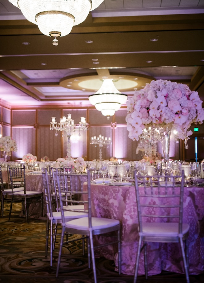 A 2016 wedding reception with large floral centerpieces and clear crystal. 