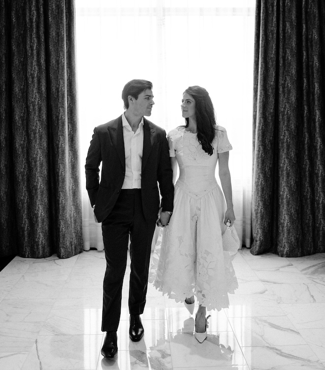 A black and white photo of Blayne and Peter holding hands and gazing in each others eye at The Post Oak Hotel. 