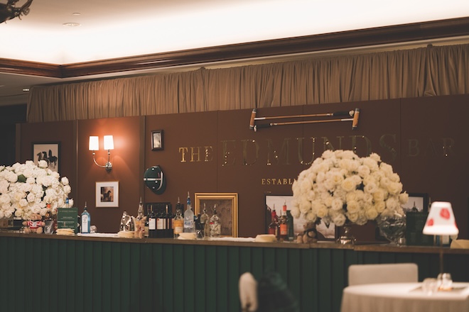 "The Edmunds Bar" with large white floral arrangements on the bar. 