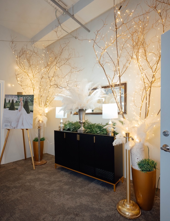 Twinkling lights on trees and Weddings in Houston signage decorating a space in The Vault. 