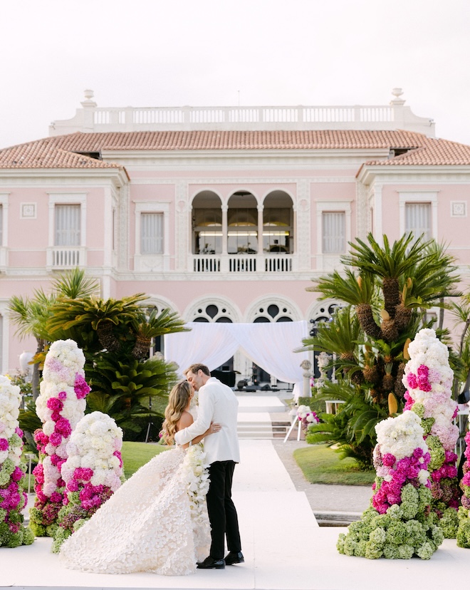 The couple share a kiss on the alter of their outdoor wedding.