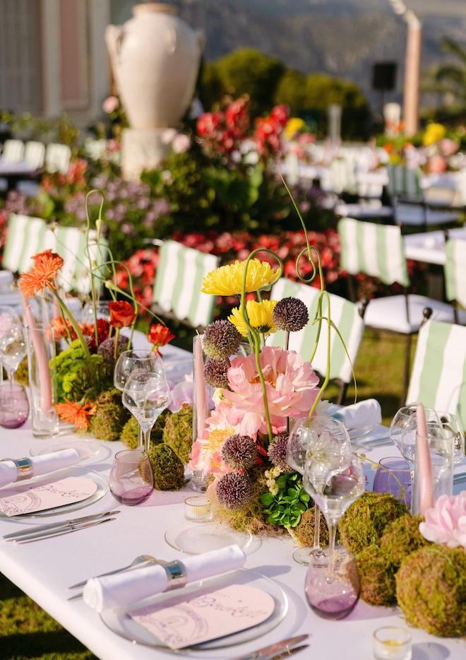 Yellow and orange flowers decorate the reception tables with moss balls. 