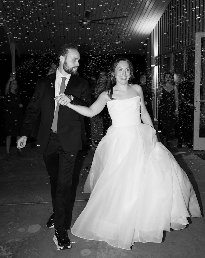 The bride and groom holding hands during their bubble send-off. 