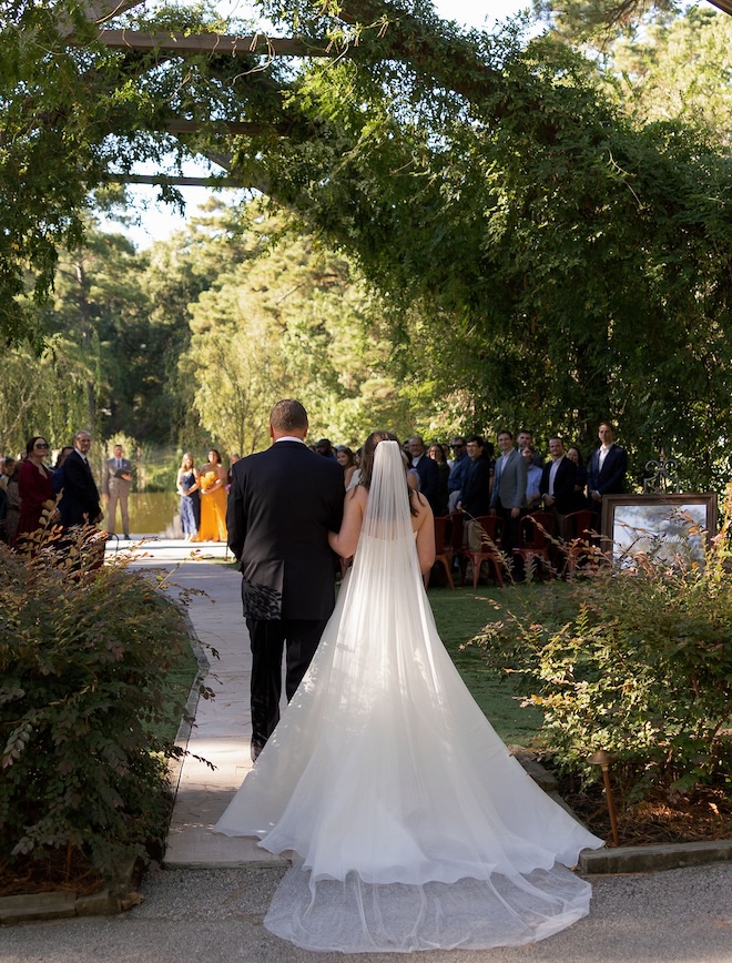 The bride walking down the aisle of the outdoor ceremony. 